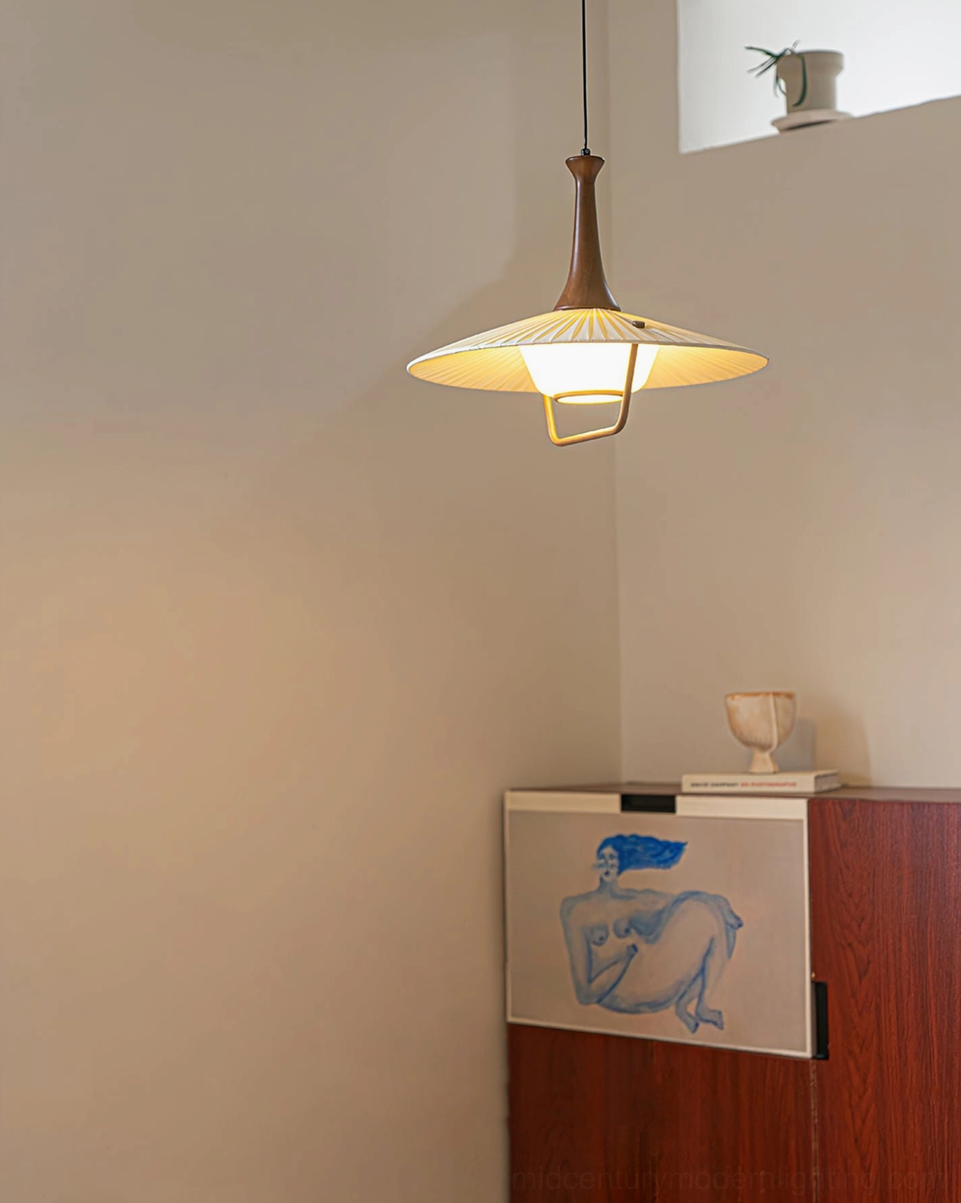 Eikon pendant lamp illuminated low-angle view showing warm glowing pleated fabric shade