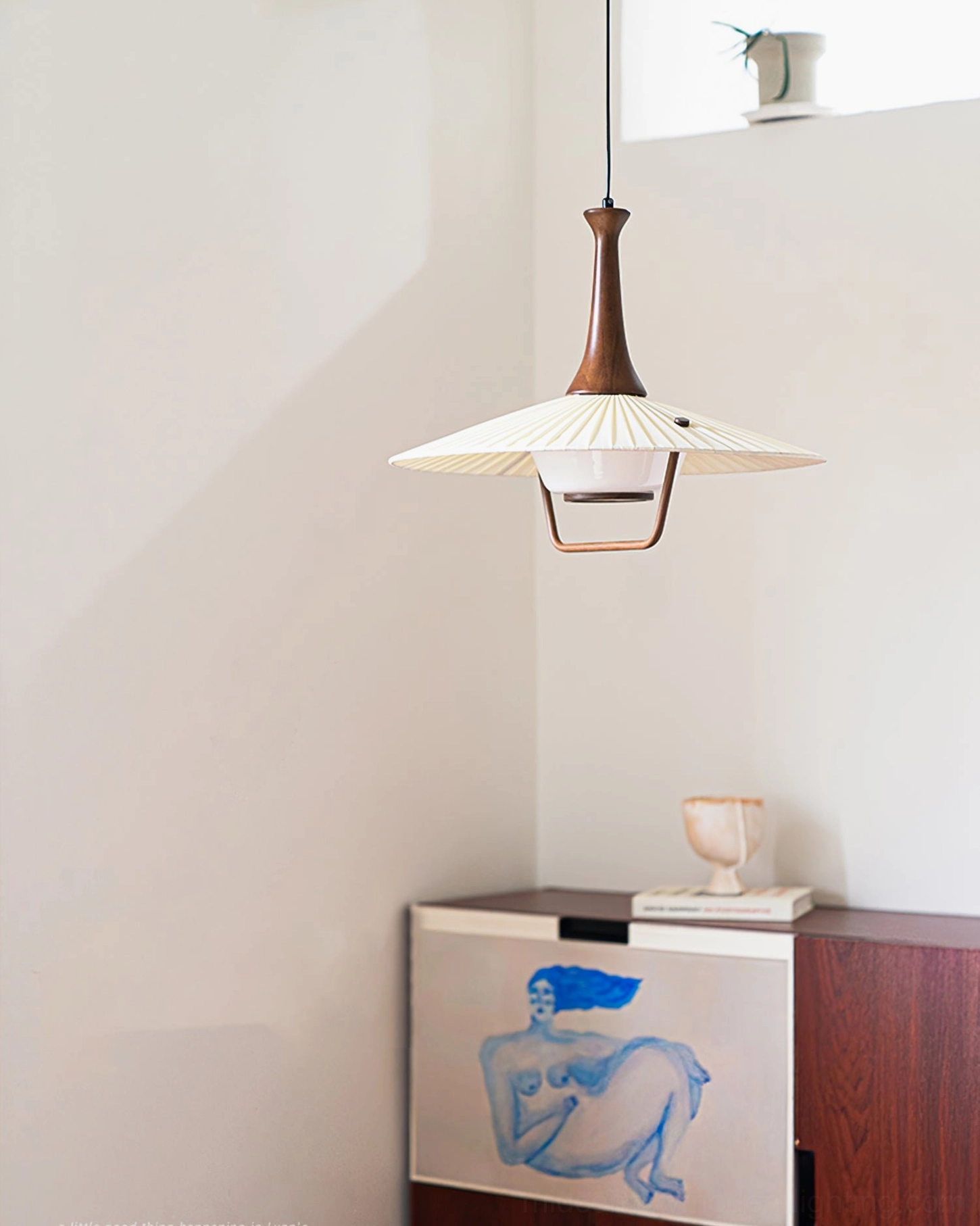 Eikon pendant lamp side profile in minimalist Nordic vintage home corner with art cabinet
