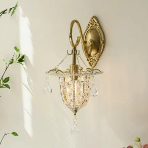 Overhead view of Eilers wall mounted crystal sconce in sunlight, highlighting transparent crystal beads and polished brass hardware against minimalist white wall background