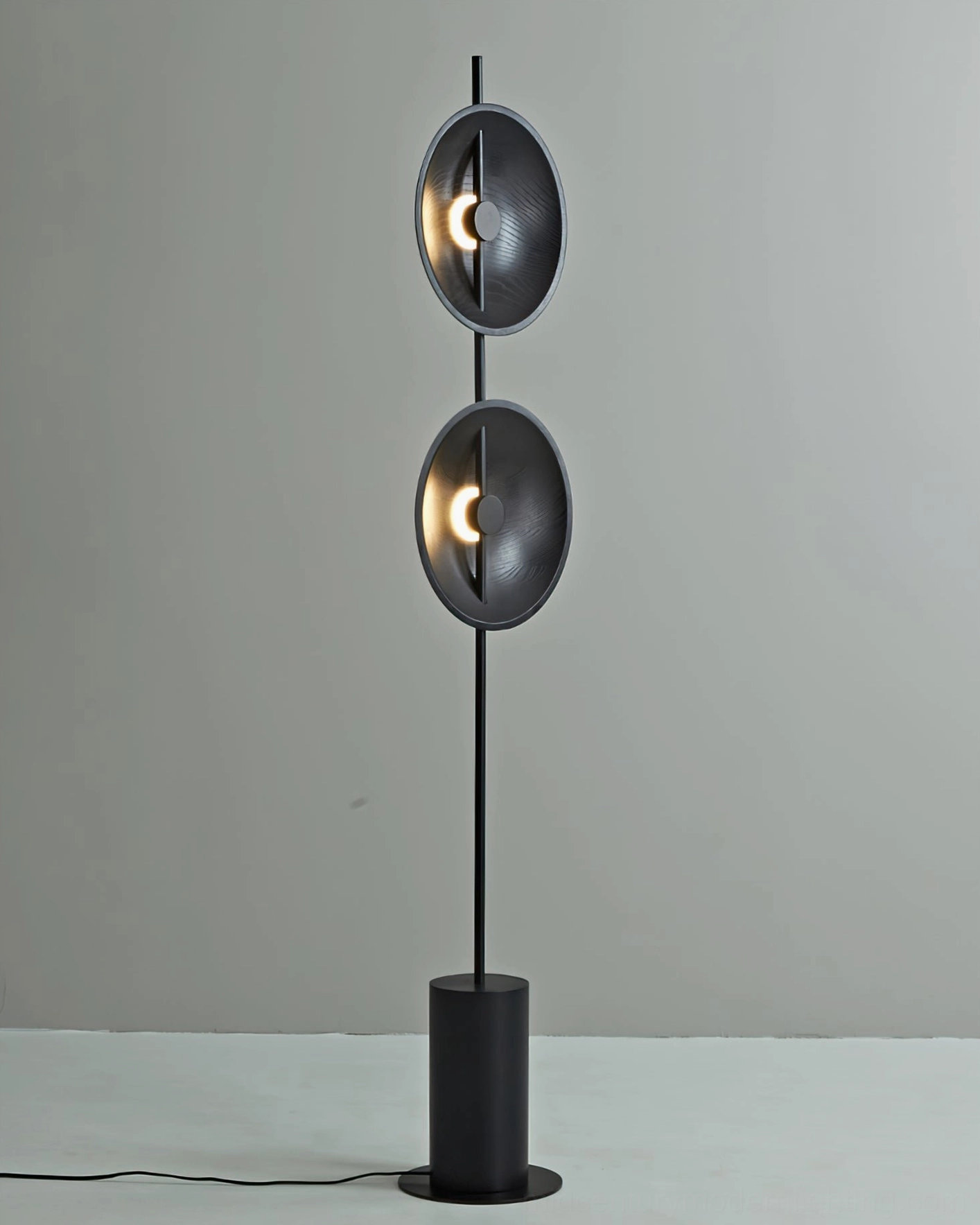 Black Eine floor lamp with concave round metal shades and cylindrical base minimalist aesthetic
