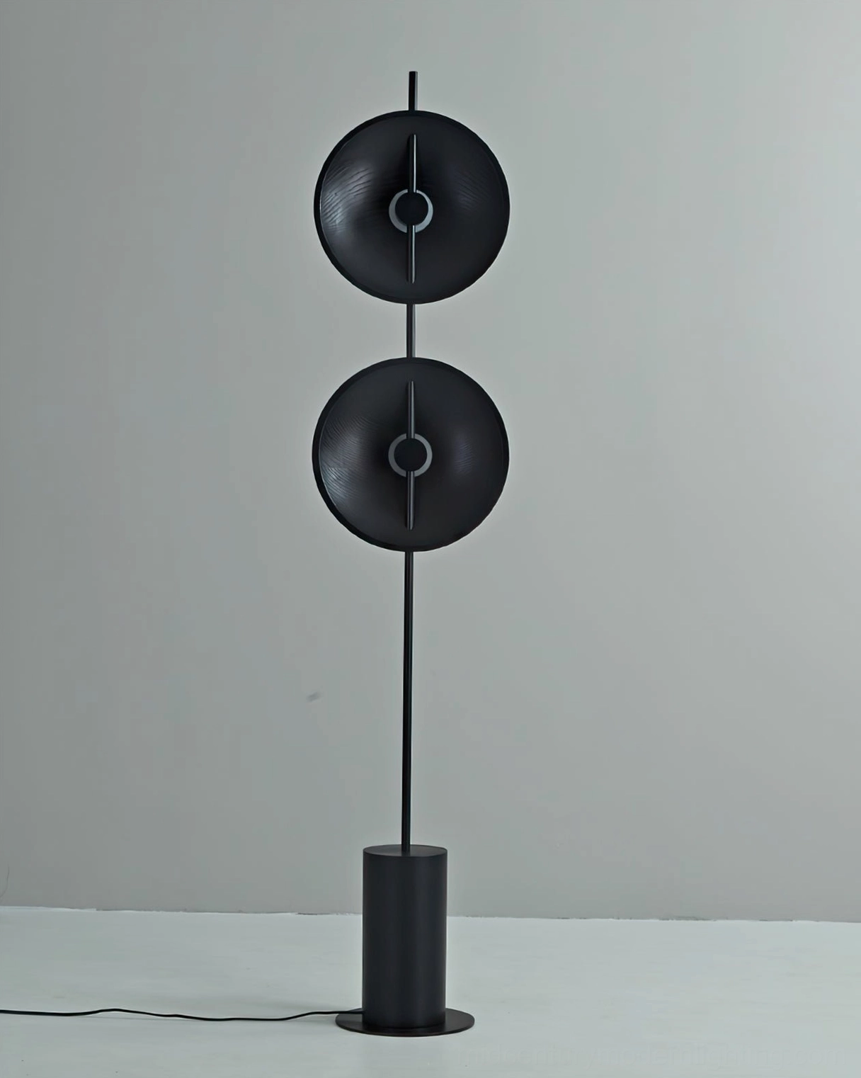 All-black Eine floor lamp with concave metal discs and contemporary minimalist design