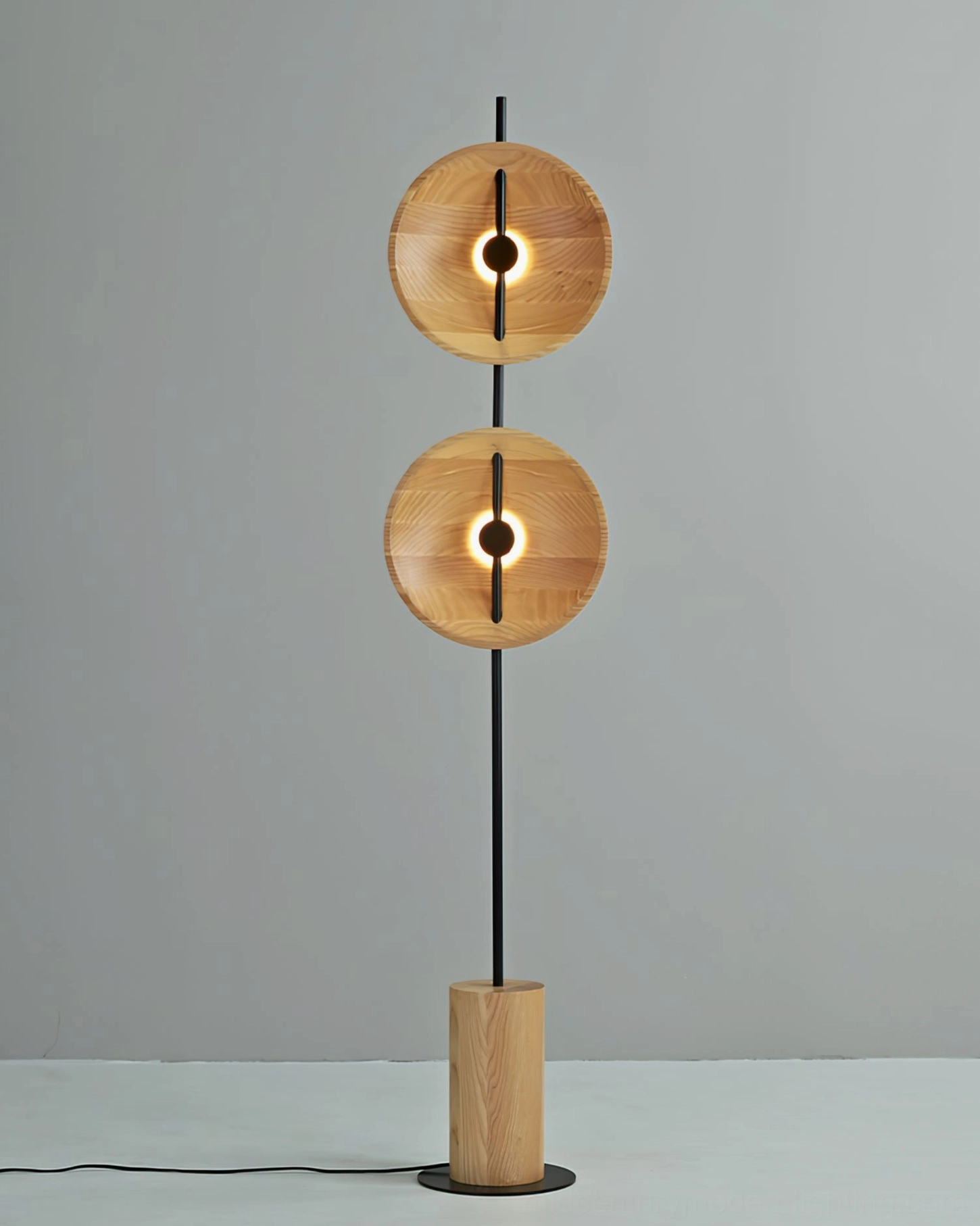 Eine floor lamp illuminated with warm golden ambient light glowing from wood disc apertures