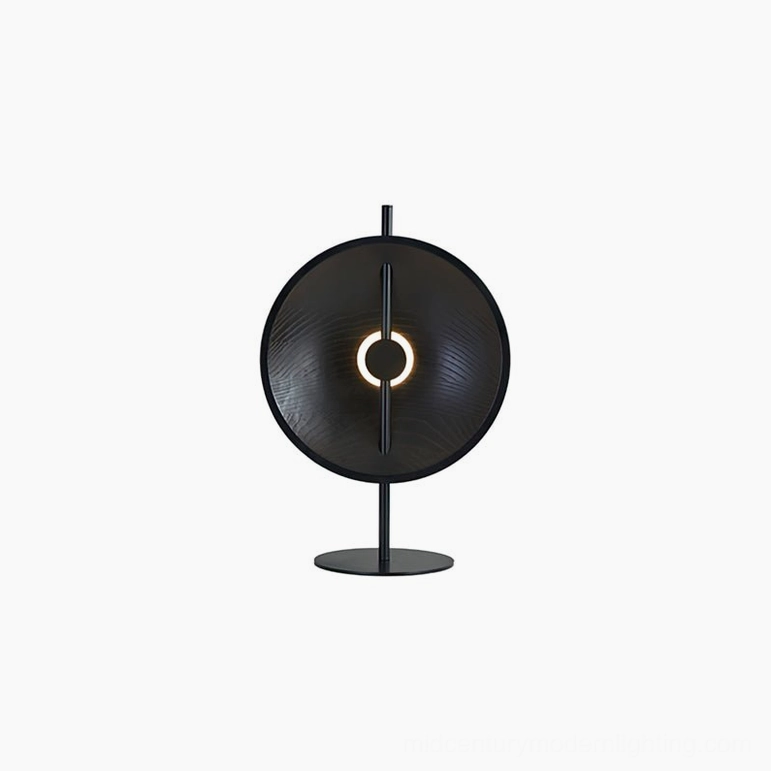 Eine table lamp in matte black finish, geometric circular shade with cutout design, sleek metal base frontal view