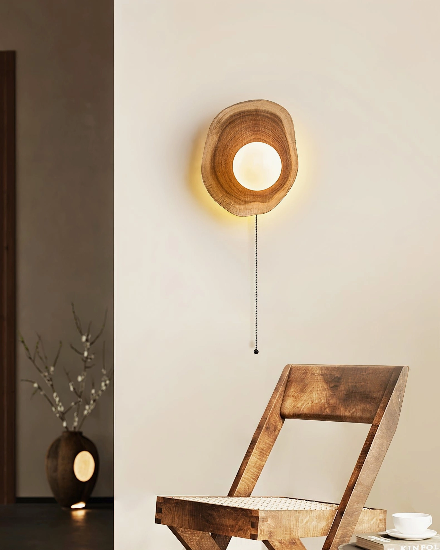 Eivor wooden pull-chain wall lamp in residential entryway with wooden furniture and floor vase, exemplifying wabi-sabi design principles and warm lighting