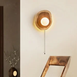 Eivor wood wall light installed in residential entryway with wooden chair and decorative vase, demonstrating warm ambient lighting in interior design context