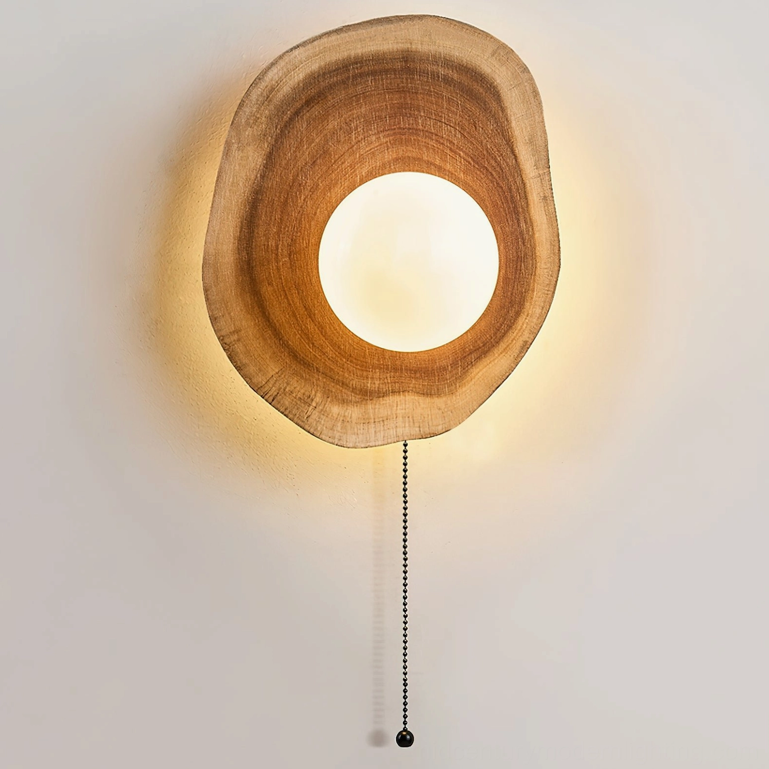 Eivor wall sconce with frosted glass globe illuminated, demonstrating warm diffused light quality and atmospheric ambiance in minimalist space