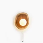 Eivor wooden wall sconce with asymmetrical design and frosted glass globe, isolated frontal view showing natural wood grain and minimalist Nordic aesthetic