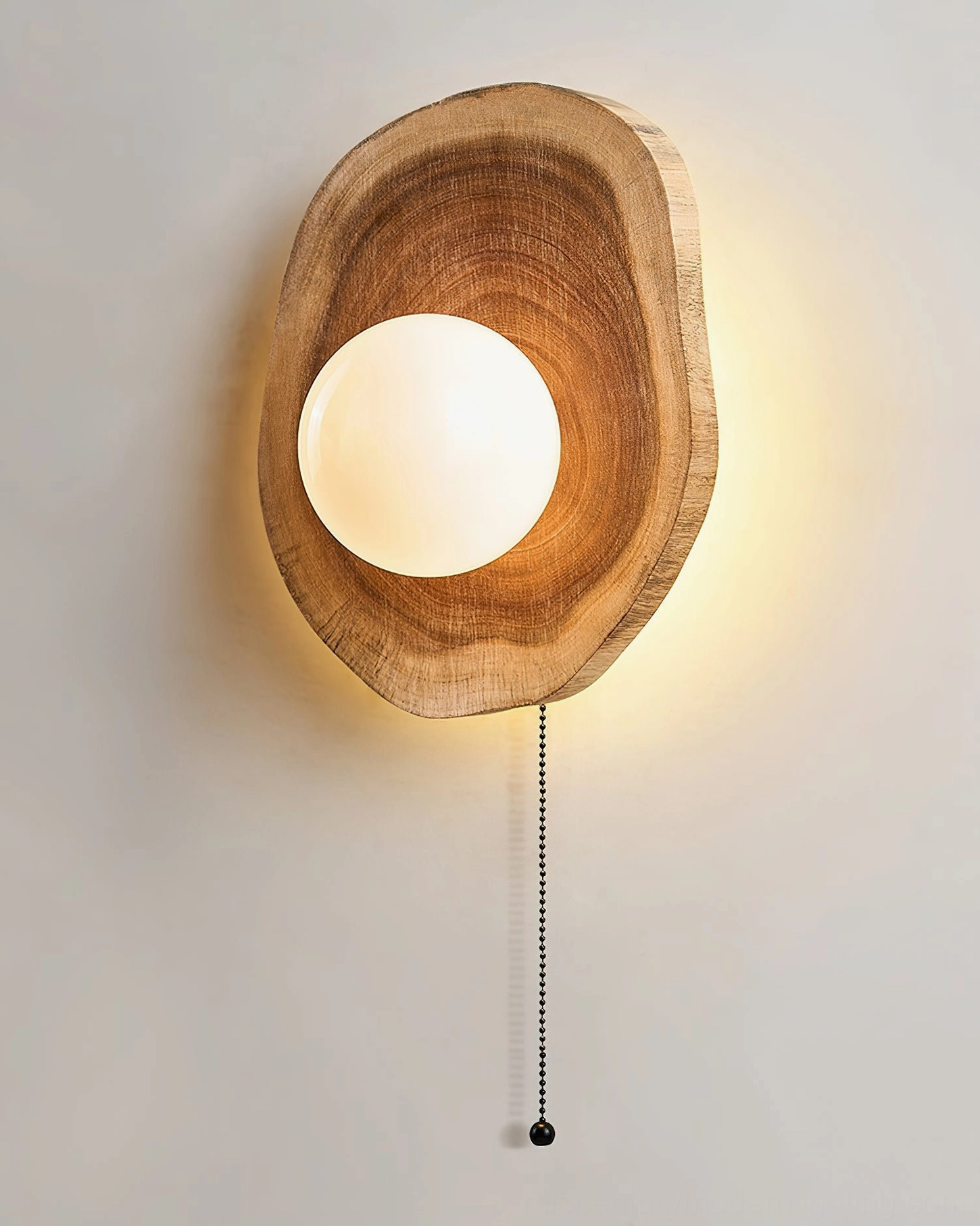 Eivor wooden wall sconce in natural walnut tone showcasing unique asymmetrical carved design and frosted glass orb light diffuser