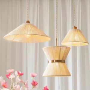 Assorted Elara woven pendant lights in multiple sizes arranged together, showcasing hourglass and conical shapes with warm beige tones and gold finishes in interior setting