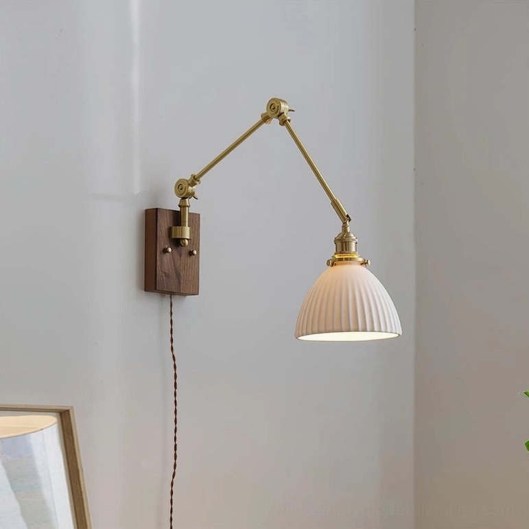 Elia swing arm wall lamp three-quarter view in corner setting with conical ribbed glass shade and brass hardware
