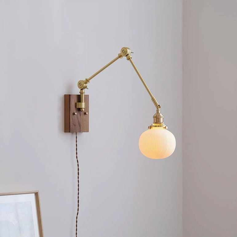 Elia swing arm plug-in wall lamp front view with smooth frosted glass shade and brass metal arms
