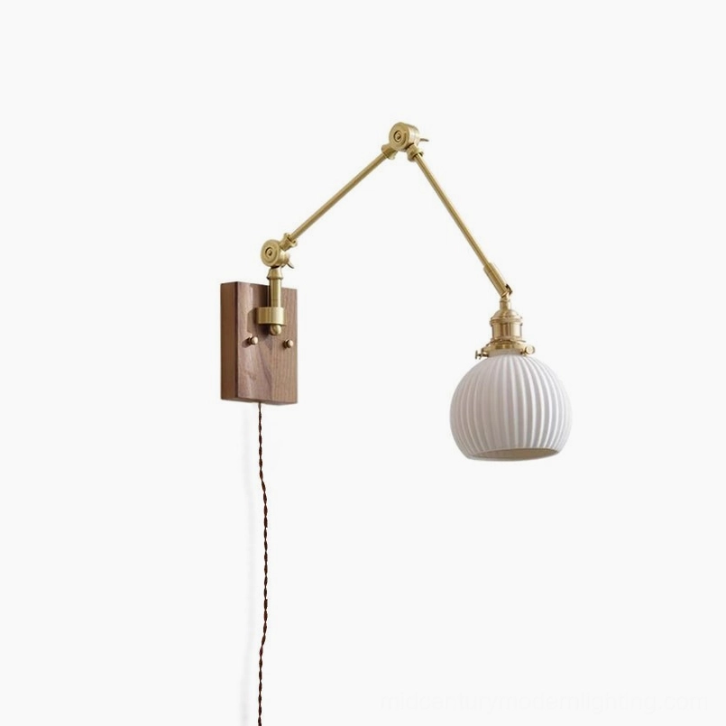Elia swing arm wall lamp front view with fully ribbed white glass shade, brass arms, and walnut wood mounting