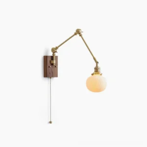 Elia swing arm wall lamp with brass articulated arms, walnut wood backplate, and smooth spherical glass shade - studio front view on white background