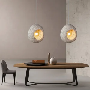 Two matching Elian stone pendant lamps in modern dining room with warm ambient lighting and neutral palette