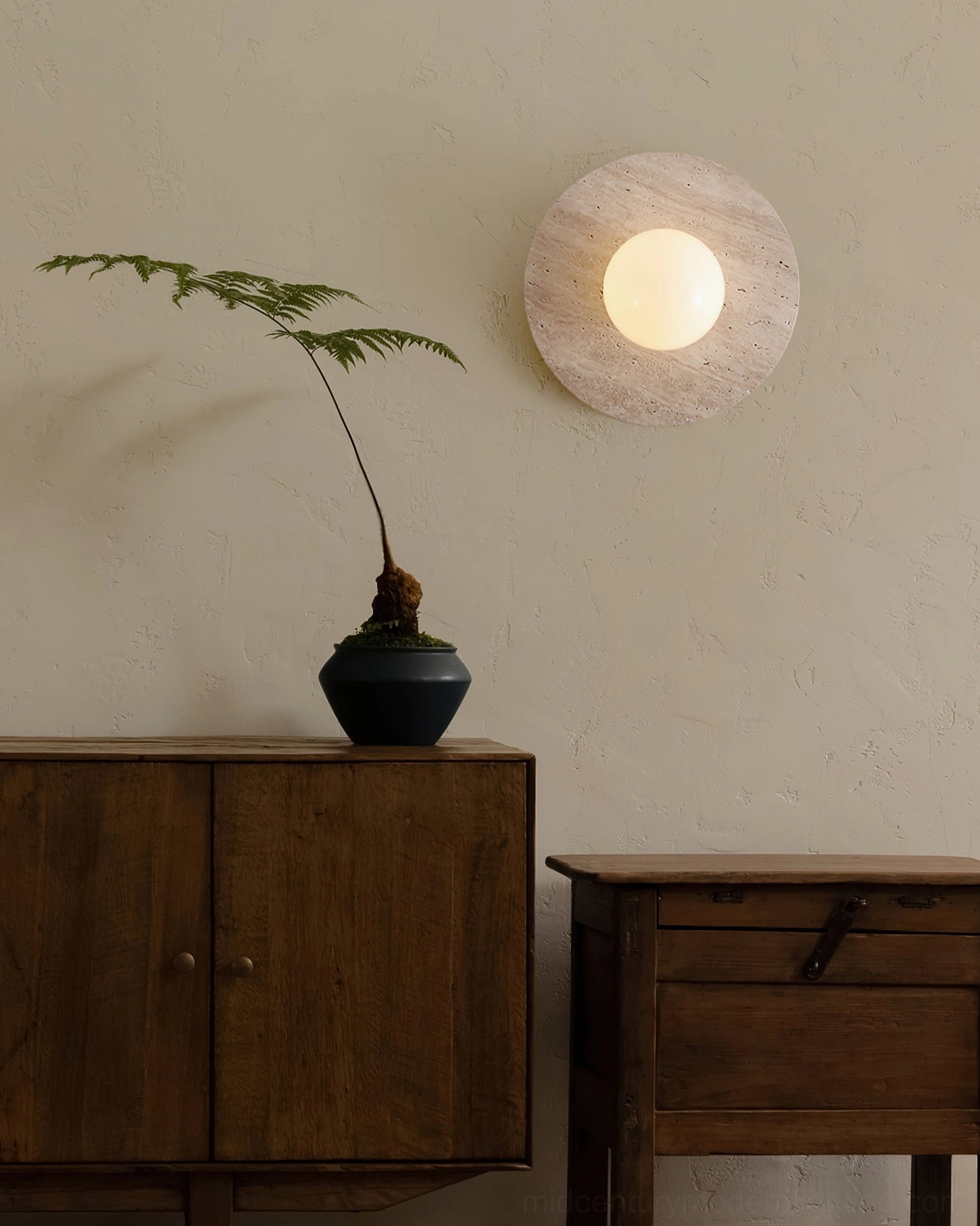 Elira stone wall lamp styled with vintage wooden cabinet and potted fern plant, natural material pairing