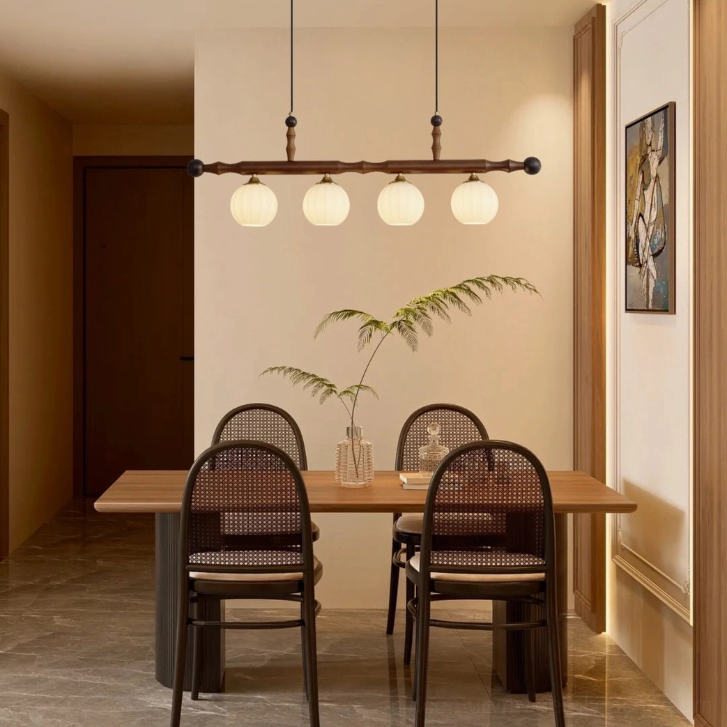 Elisha mid-century modern pendant chandelier suspended above dining table in warm traditional dining room setting
