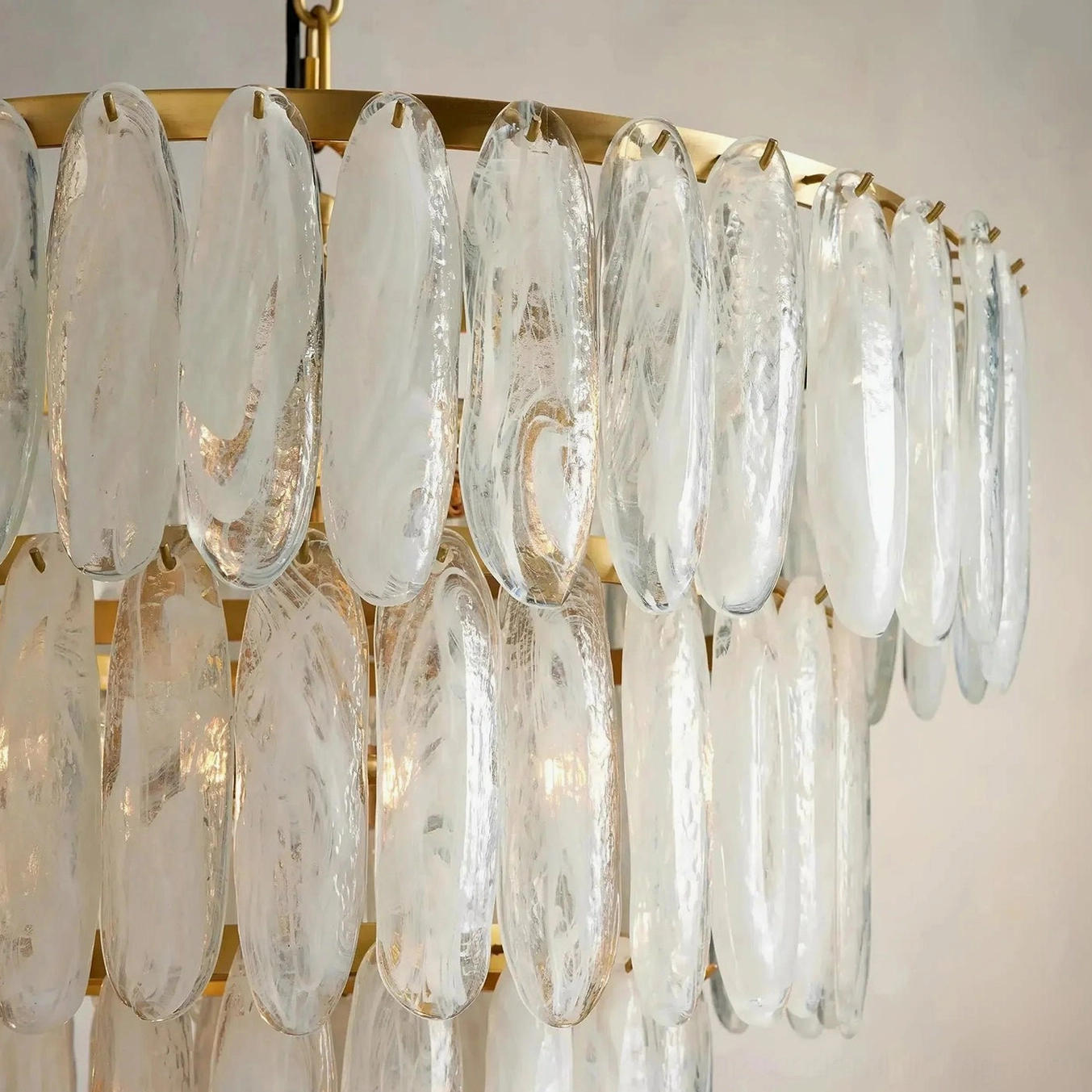 Close-up detail shot of Ellington chandelier frosted glass texture and brass hardware showing craftsmanship of oblong frosted glass shades and architectural metalwork