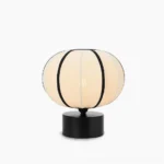 Ellos mid-century modern table lamp with beige fabric shade and black trim, front view on white background