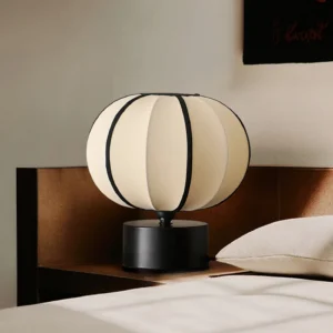 Ellos fabric lantern table lamp in bedroom setting on nightstand with warm neutral décor