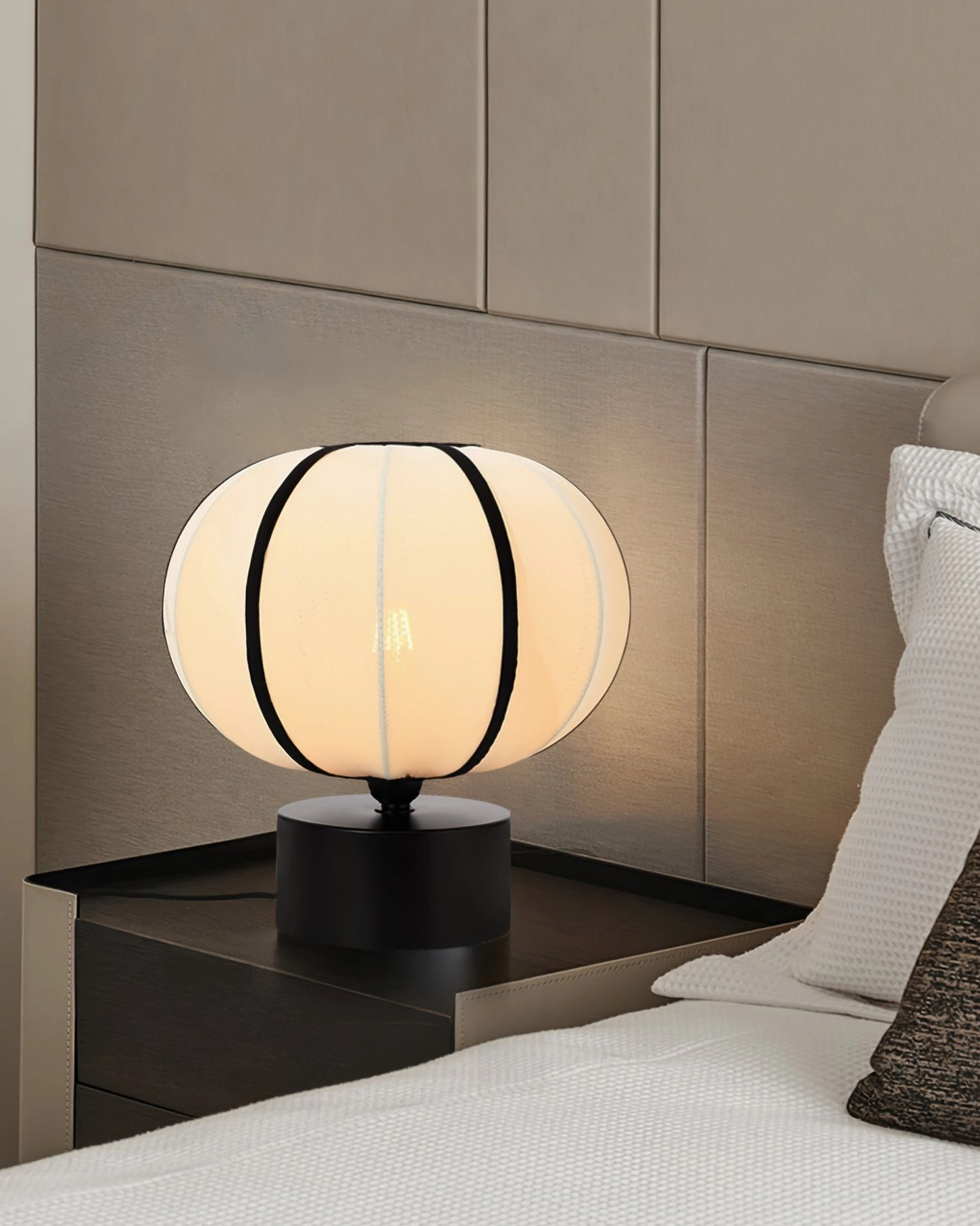 Ellos mid-century lamp on nightstand with padded fabric headboard and warm neutral tones