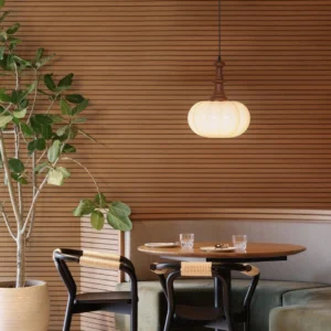 Eloise pendant lamp glowing warm light retro dining room with wooden slat wall and mid-century furniture