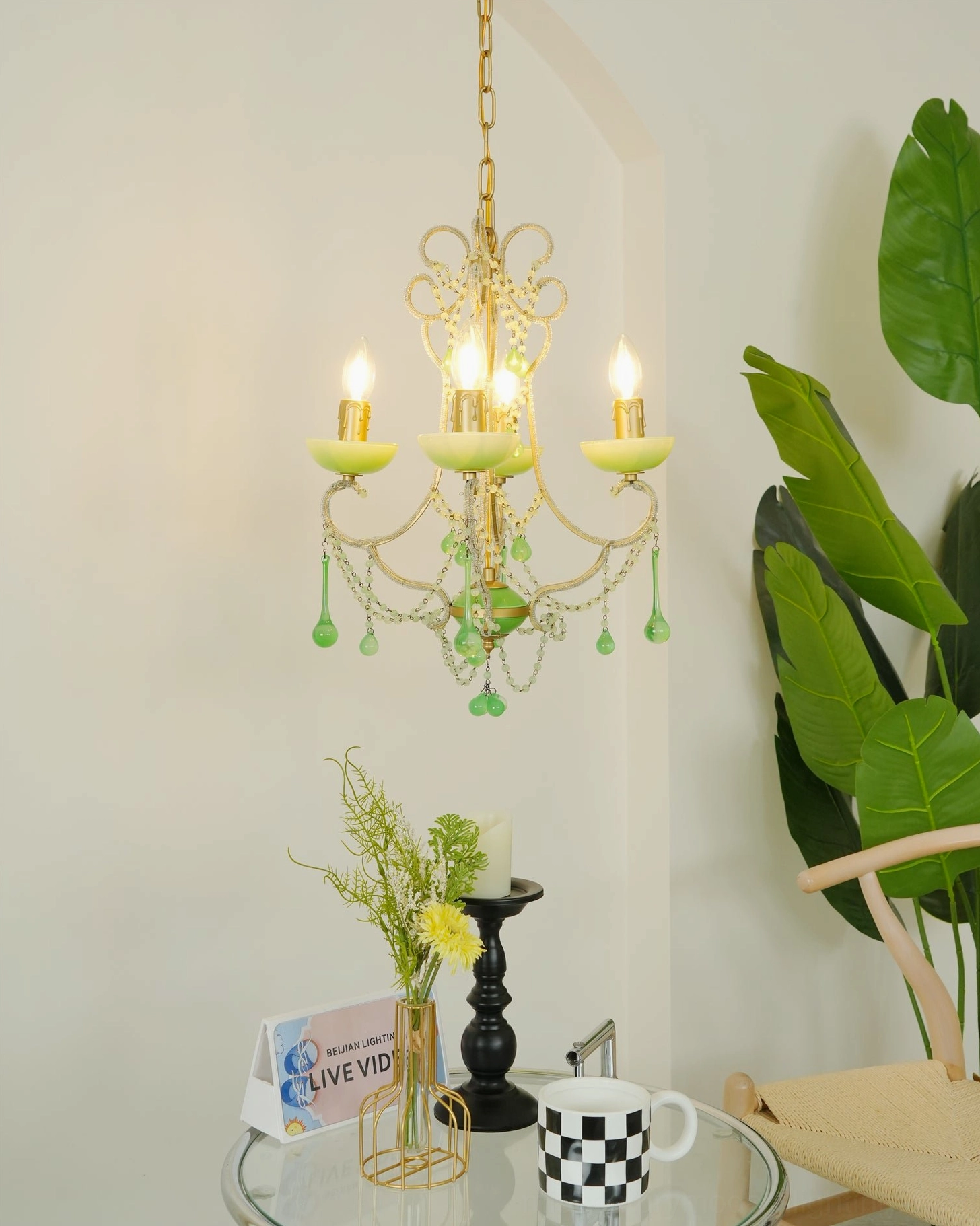 Mini emerald glass chandelier with compact scrollwork frame and hanging green glass pendant details