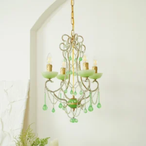 Vintage emerald glass chandelier with gold suspension chain displayed in minimalist studio setting with arched wall