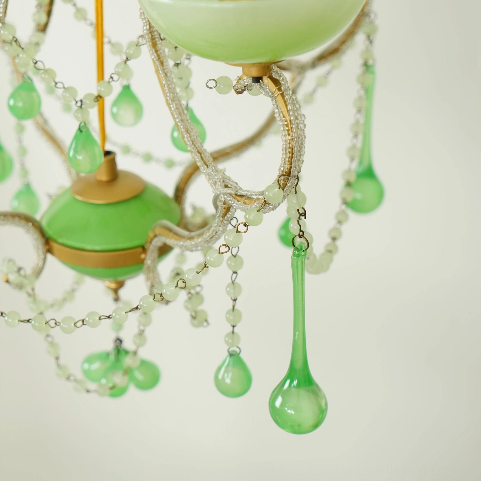 Emerald and gold vintage-inspired Murano chandelier creating warm ambient lighting in interior space