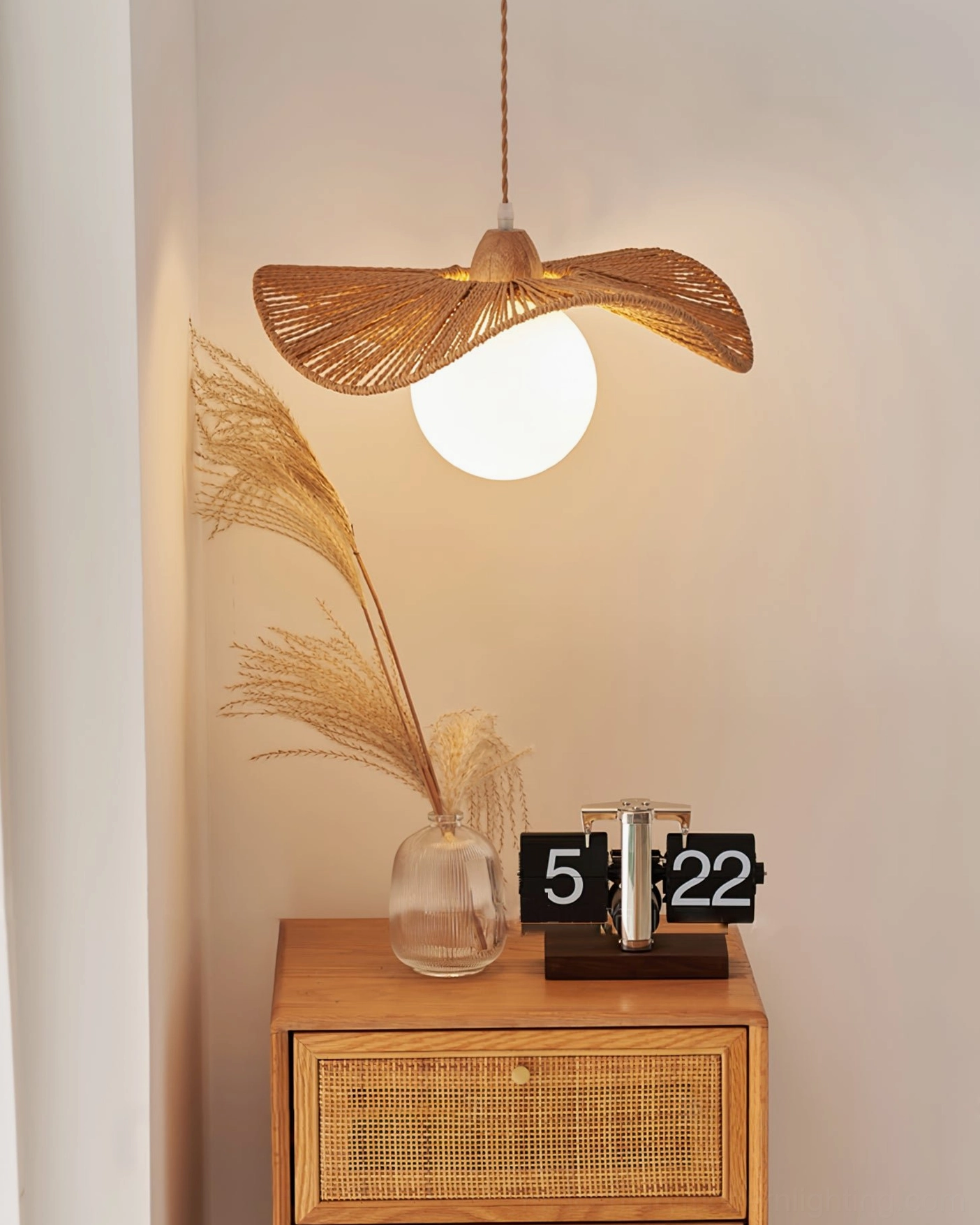 Emmi rope pendant lamp suspended above side table with pampas grass and rattan cabinet in bohemian interior