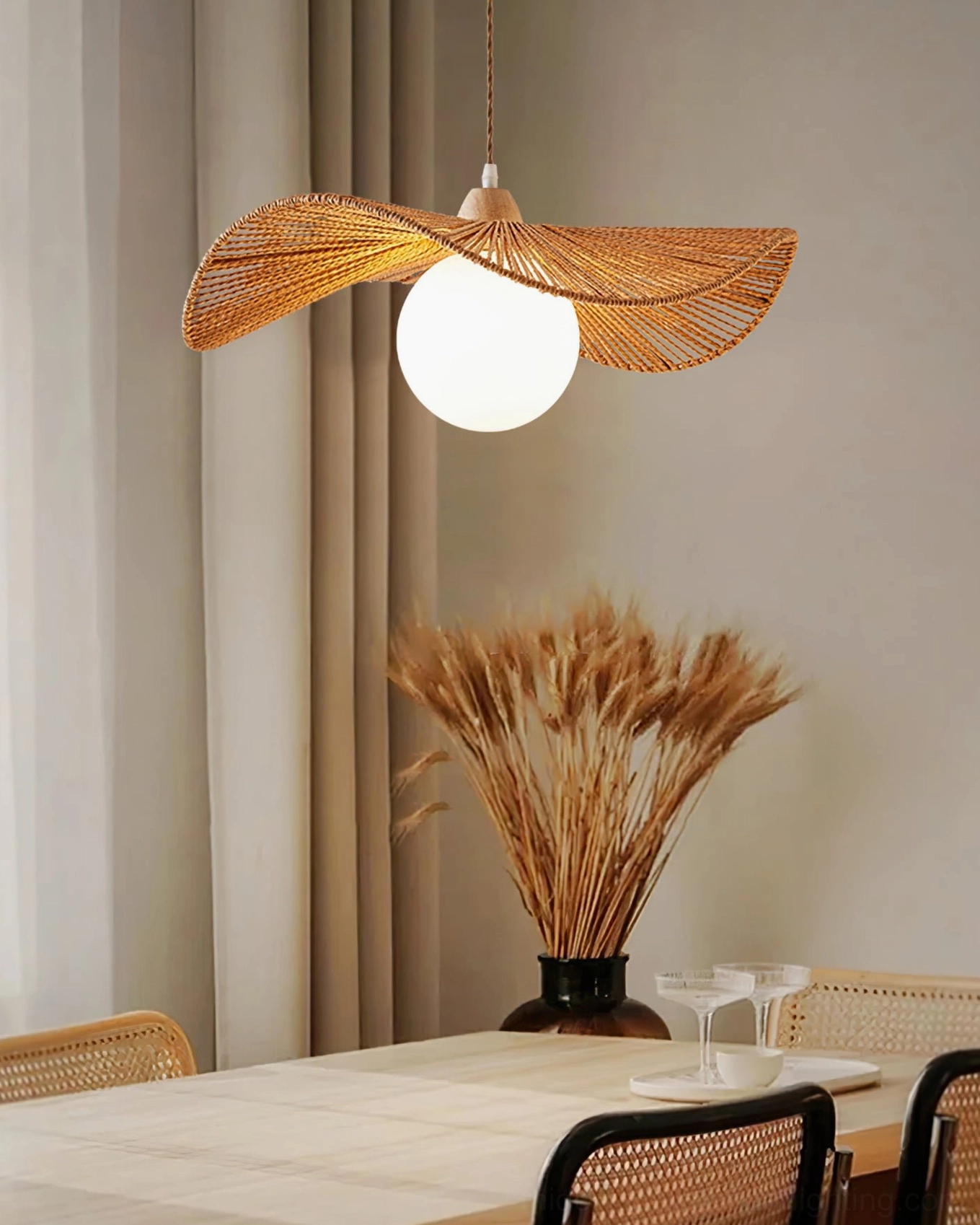 Emmi rope pendant lamp hung above residential dining table with woven dining chairs and dried floral decor