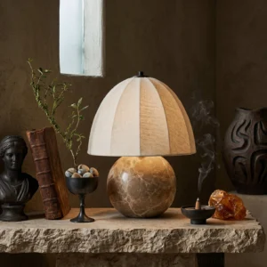 Enora modern stone lamp displayed on vintage console table with decorative accessories, three-quarter perspective