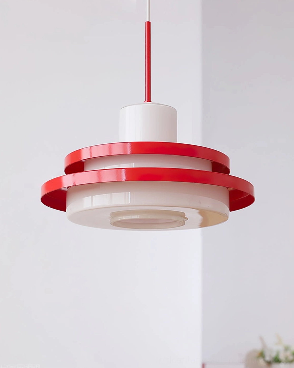 Close-up of red and white pendant lamp showing detailed layered disc construction and materials