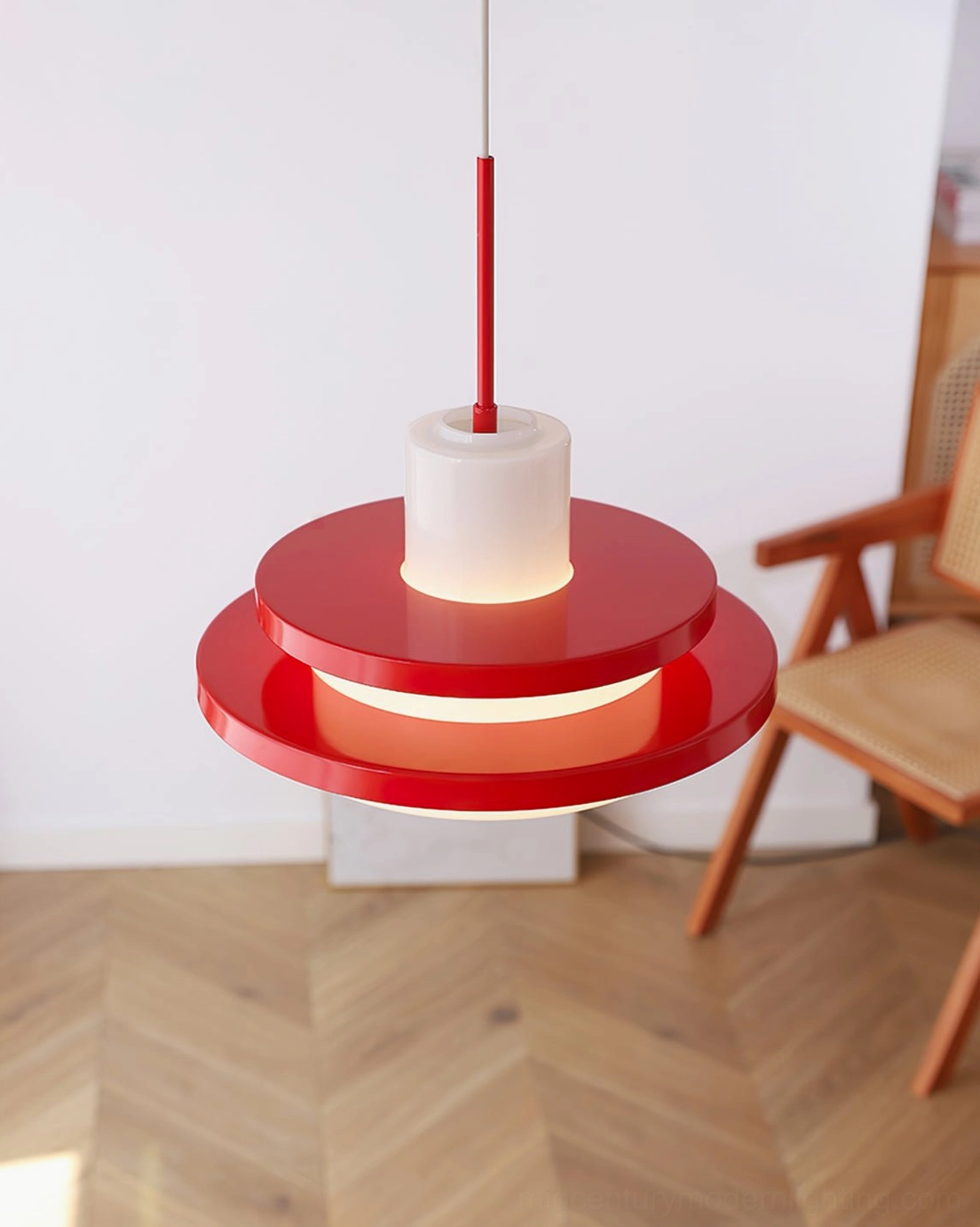 Red and white pendant lamp hanging in living space with herringbone wood floor, warm minimalist lighting