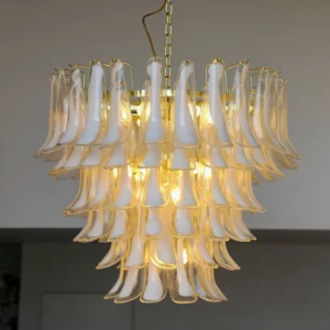 Hand-blown glass petal chandelier illuminated in modern residential living room creating warm ambient light and layered shadow effects