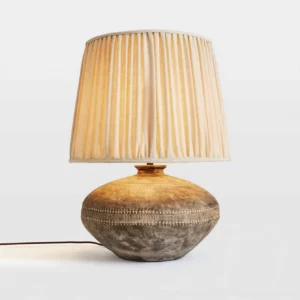 Etta table lamp front view displaying hand-embossed decorative band on ceramic base and warm linen fabric shade