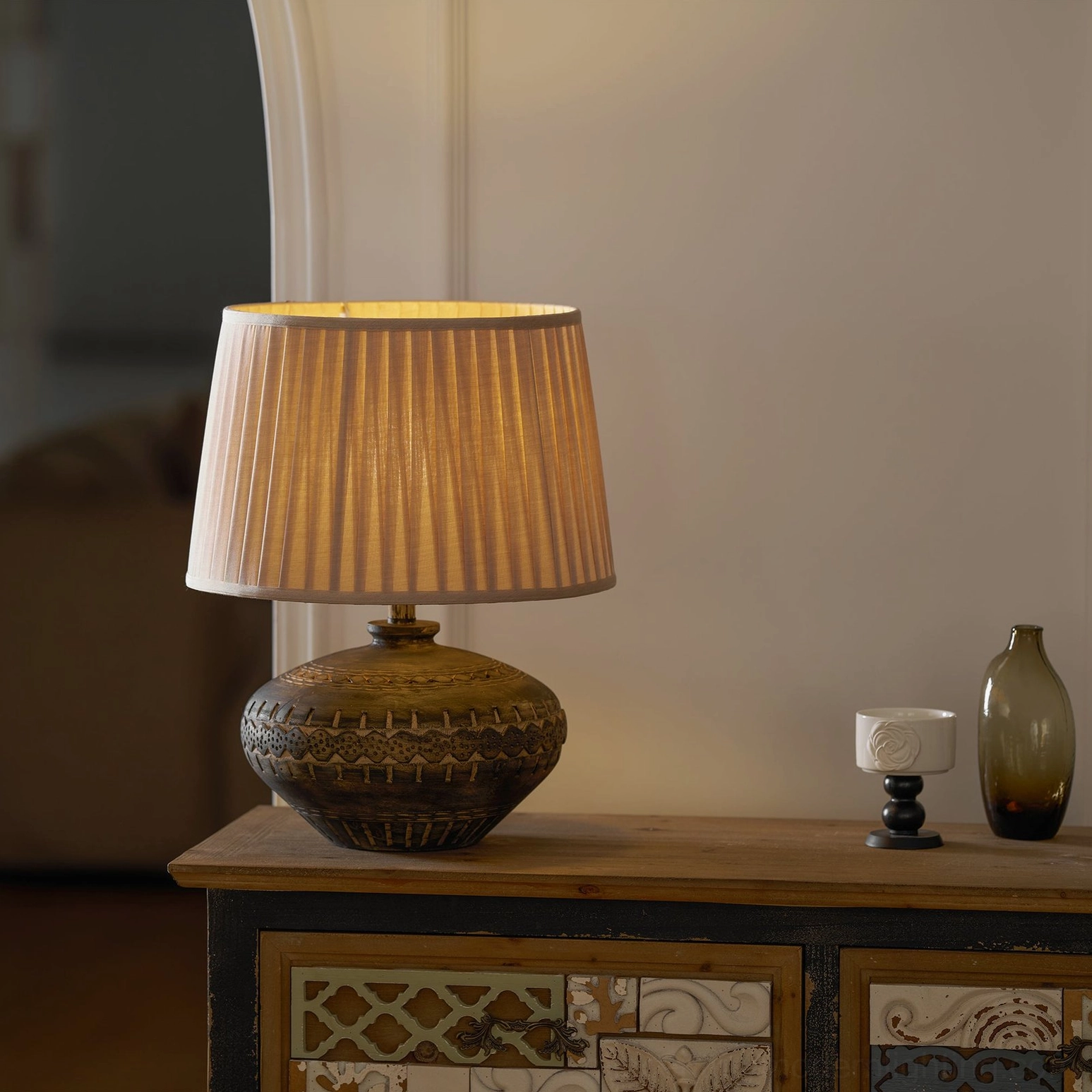 Side front view of Etta ceramic table lamp on vintage entryway console table with decorative accessories
