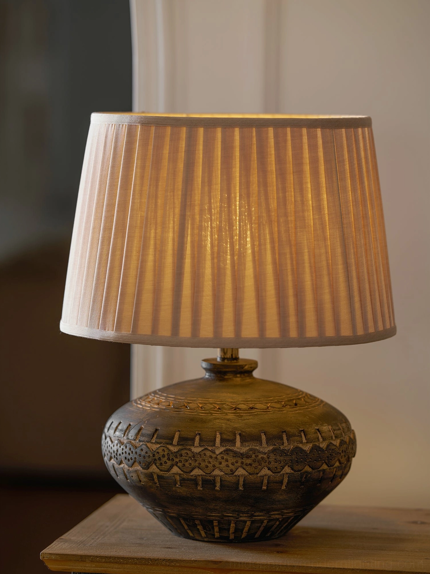 Etta ceramic table lamp displaying neutral linen shade and textured hand-crafted ceramic base in studio setting