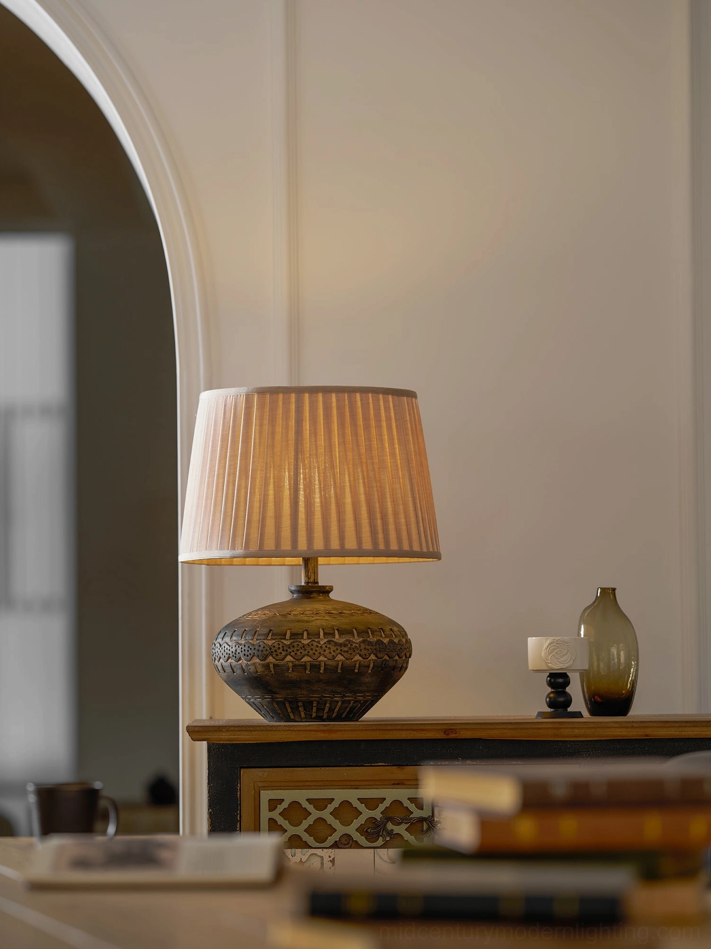Etta ceramic table lamp illuminated showing warm ambient light diffusion through neutral linen shade