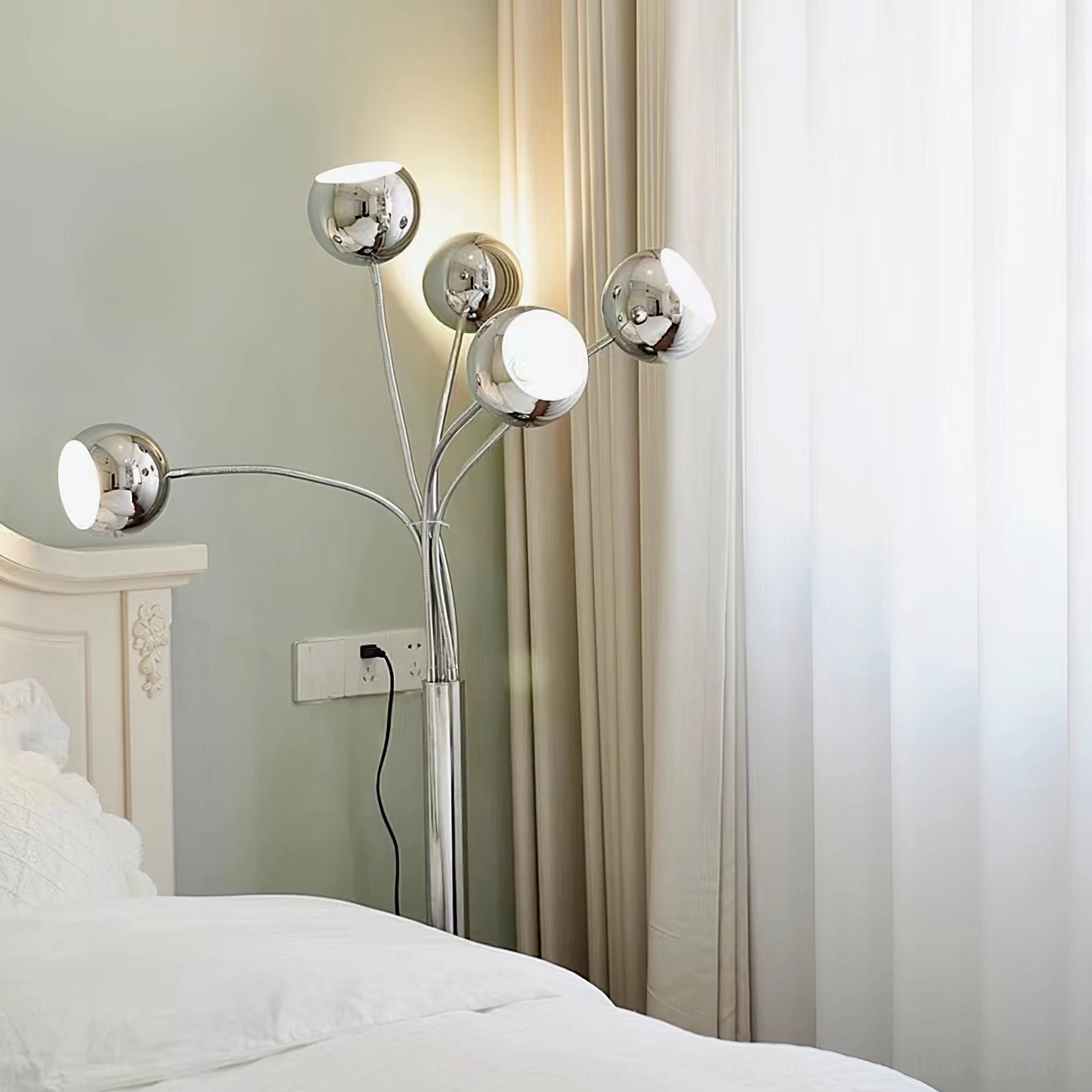 Chrome eyeball floor lamp base and lower arm configuration showing weighted circular foundation and articulation points