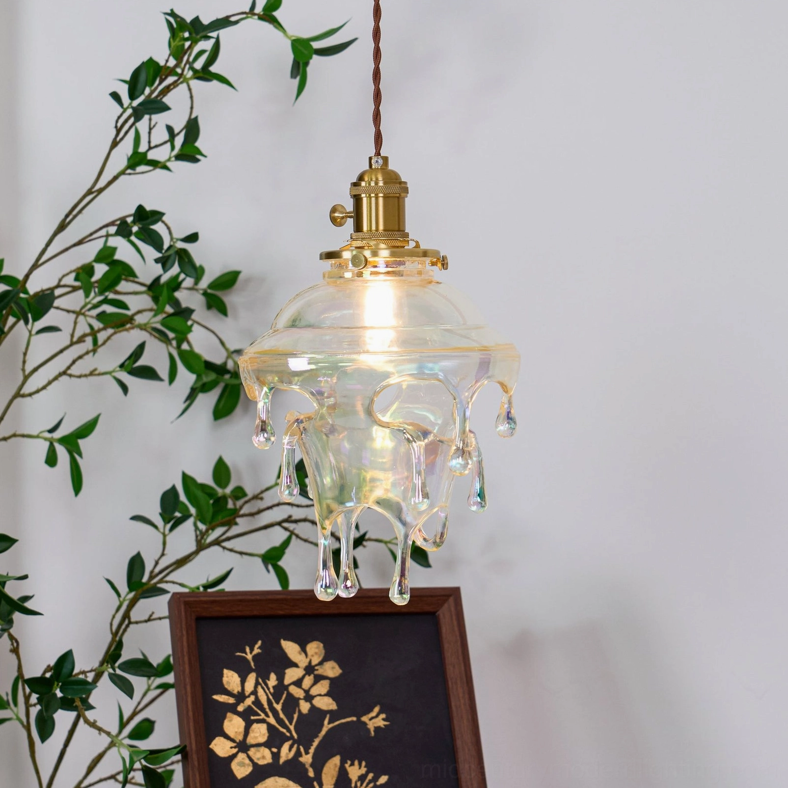 Close detail of twisted brown fabric cord and brass fixture on water droplets pendant
