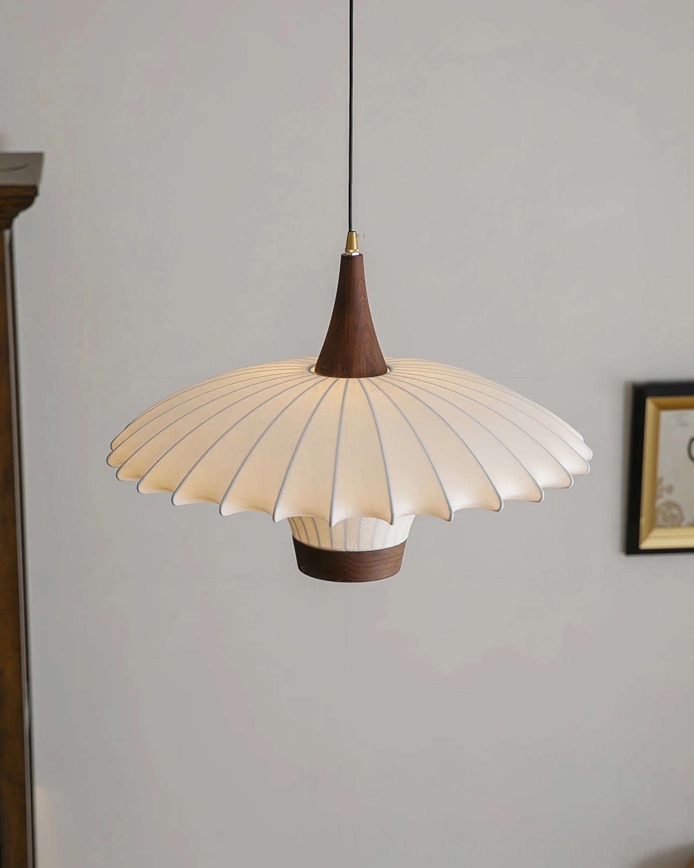 Fabric pendant lamp with solid wood hardware and decorative frame, front hanging view against minimalist wall
