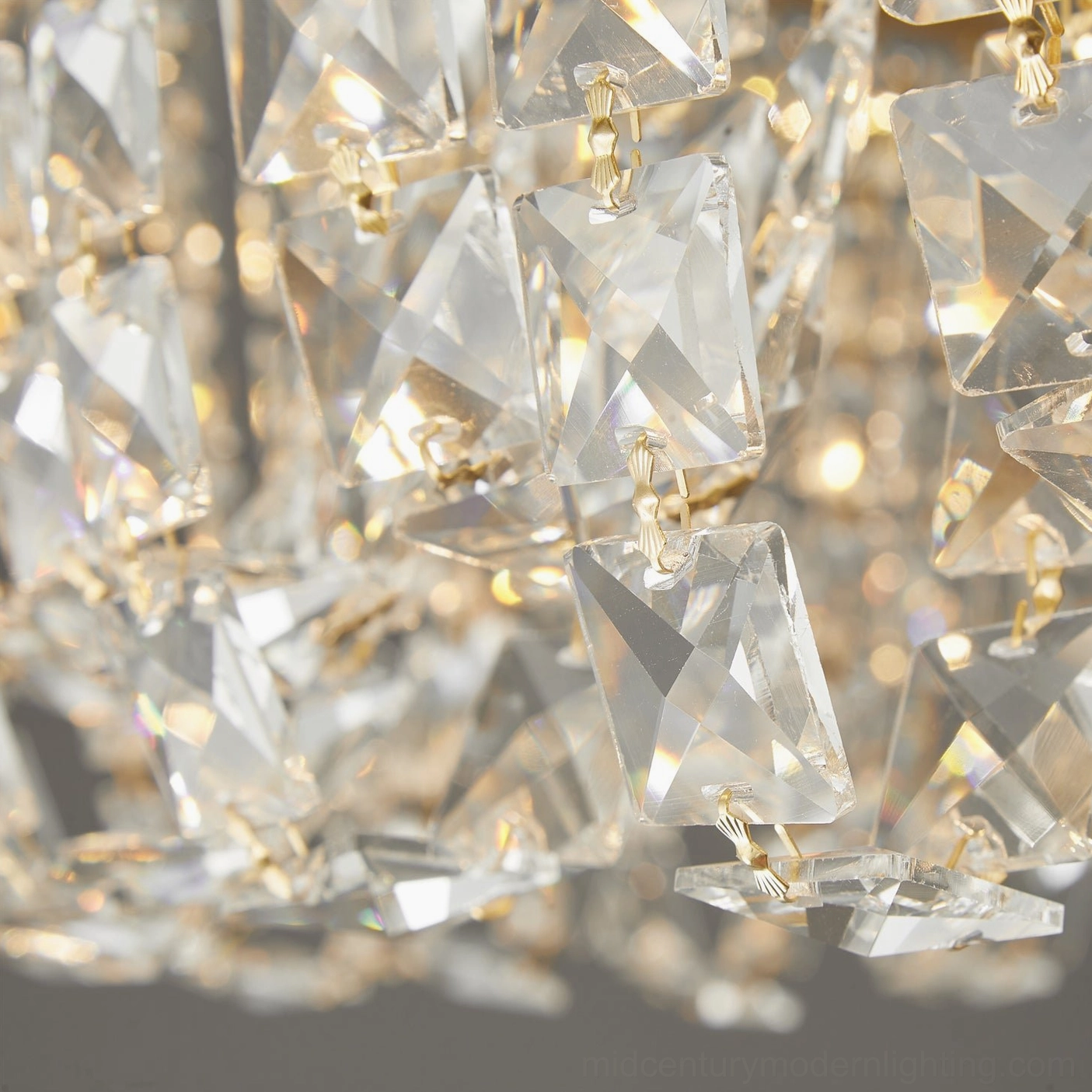 Macro photography of faceted crystal pendants with warm ambient light reflection on brass accents