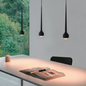 Modern teardrop pendant lamp in black providing warm downlighting over contemporary dining desk