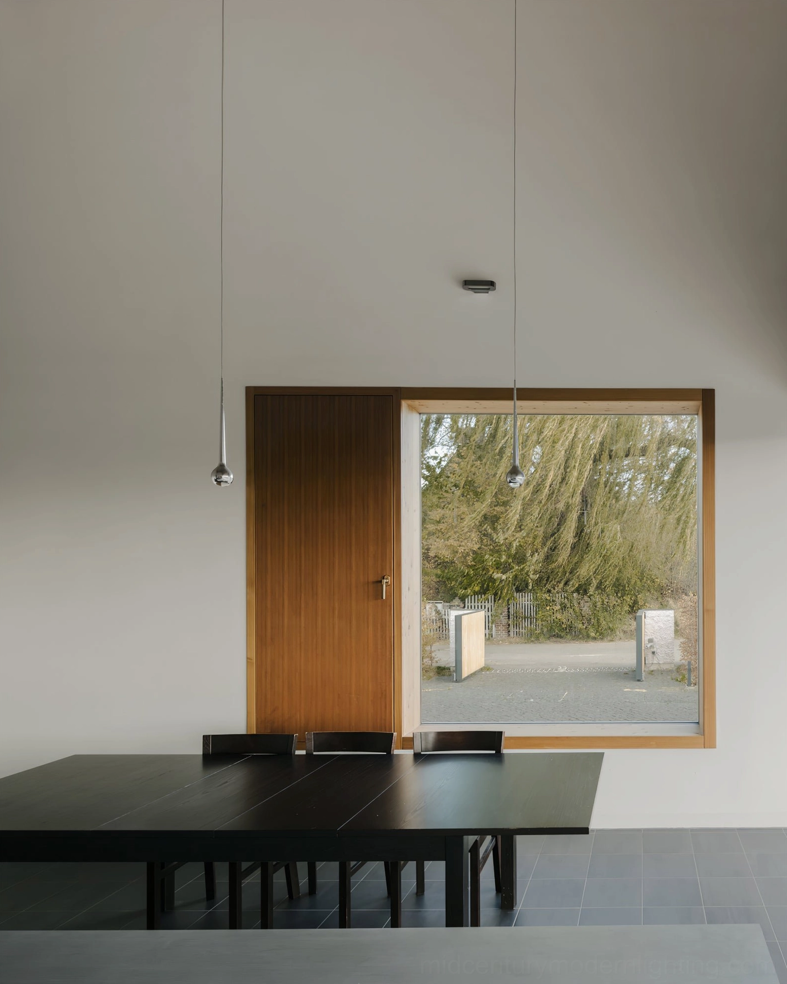 Multiple black teardrop pendants arranged in contemporary living space interior design
