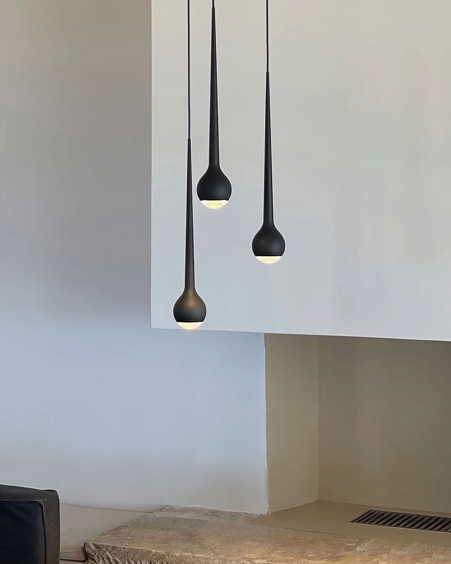 Single matte black teardrop pendant light in minimalist residential interior space