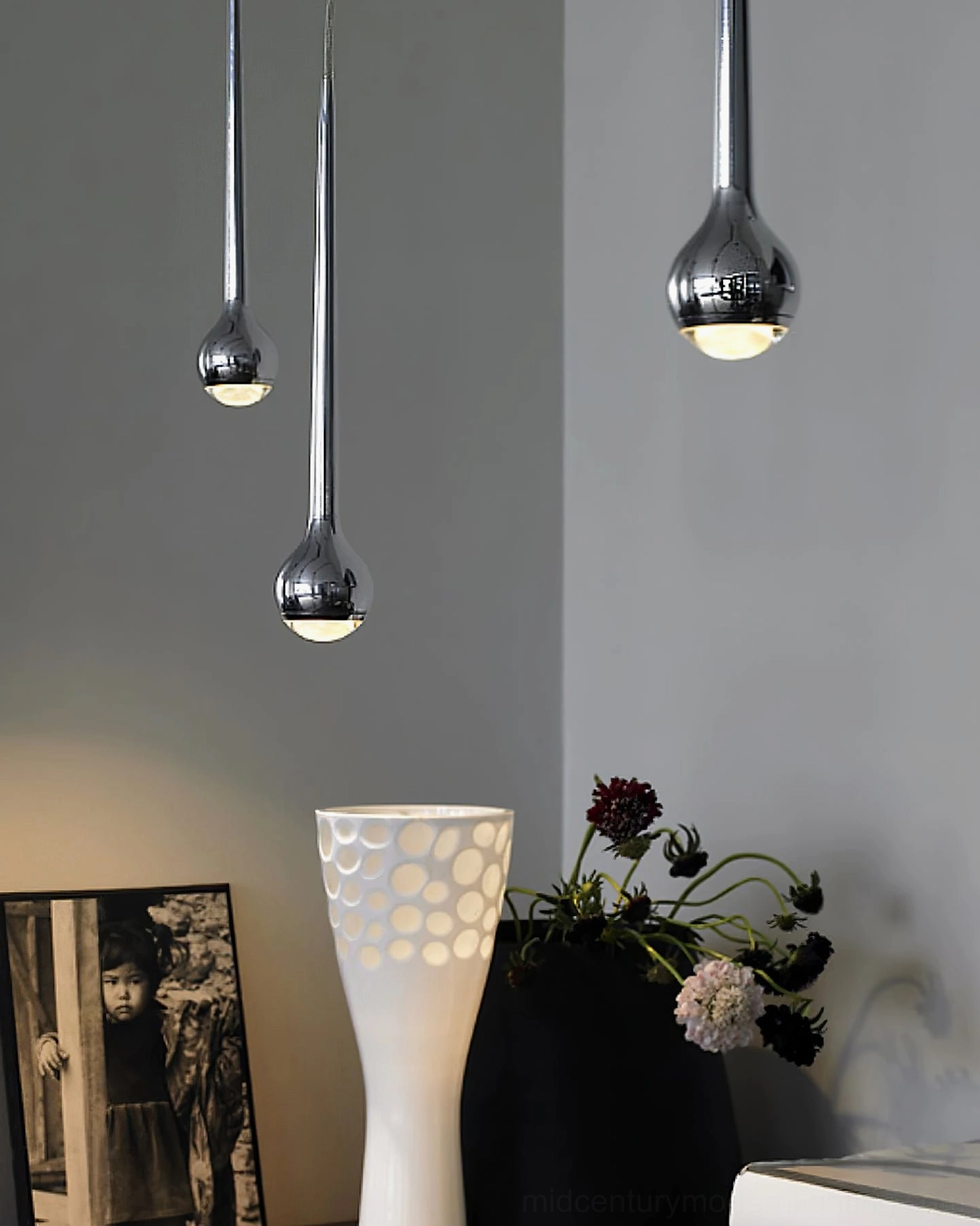 Polished chrome and silver teardrop pendant light in modern residential decorative corner