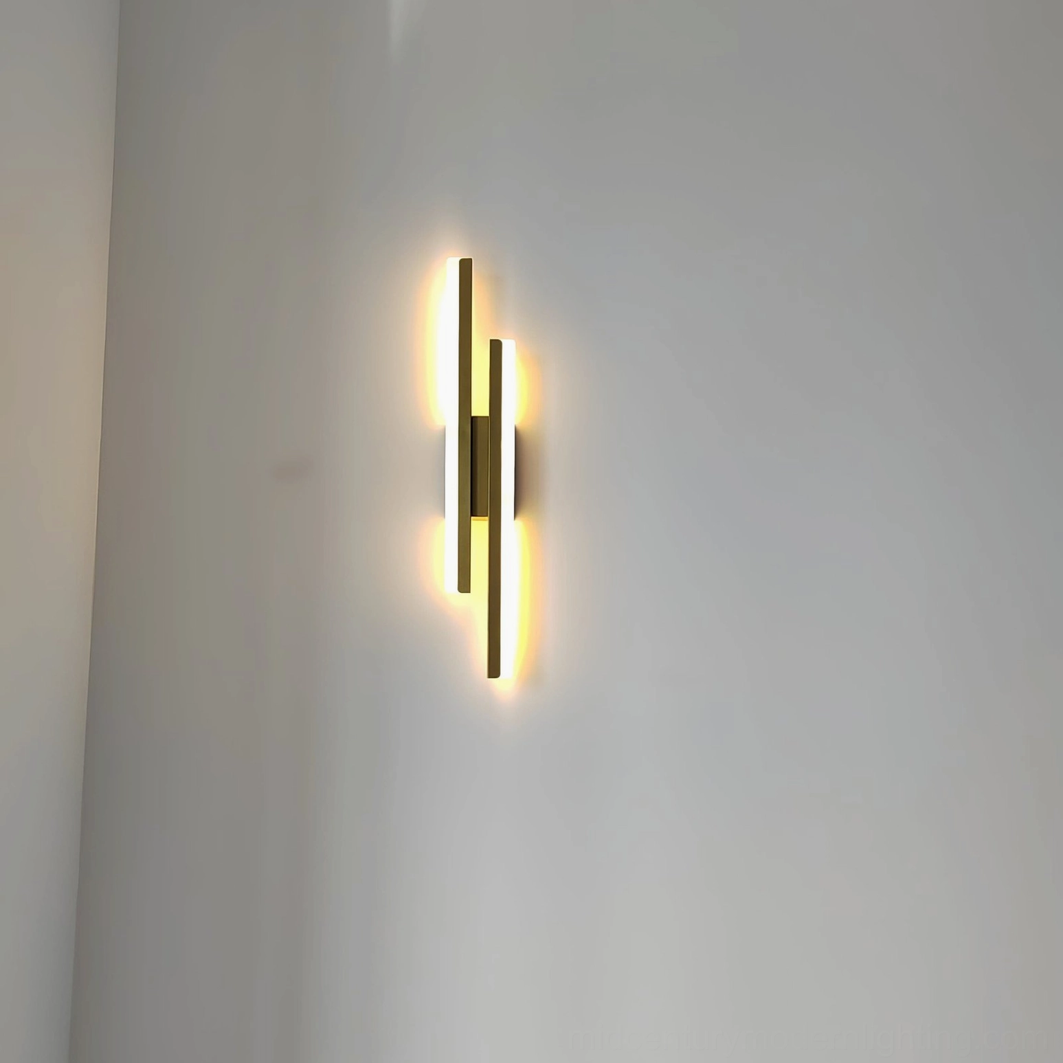 Gold-tone Fallon wall sconce with warm soft LED light in contemporary minimalist interior