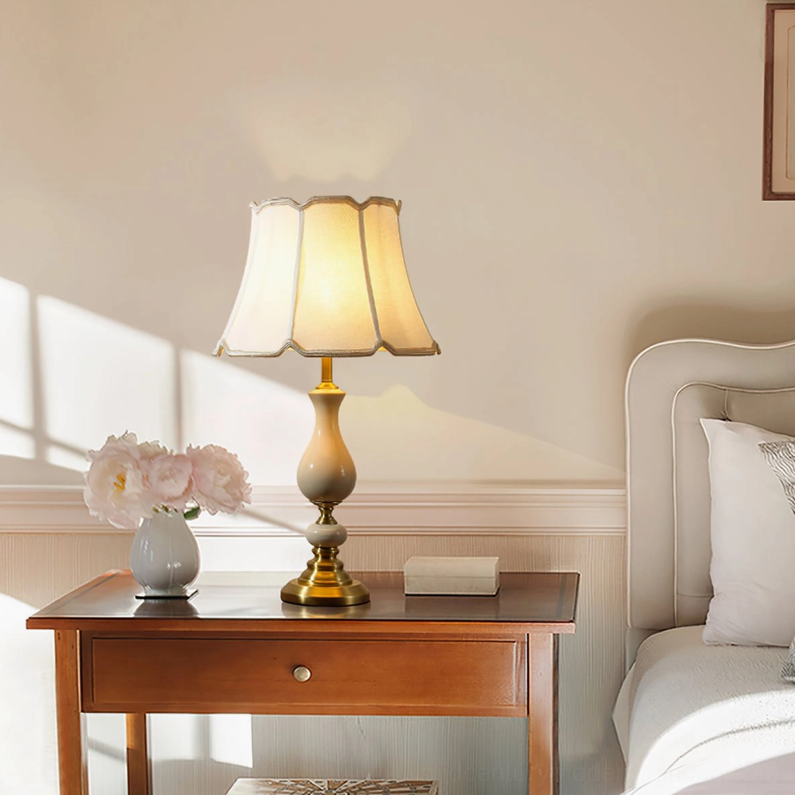 Fangio table lamp styled on wooden nightstand in bedroom with decorative vase and books