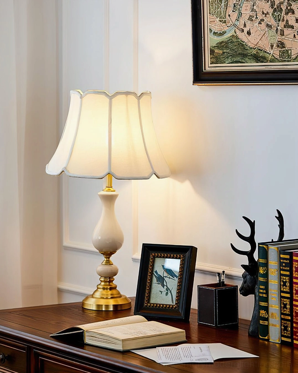 Fangio table lamp with magnolia flowers and books on wooden side table in living room