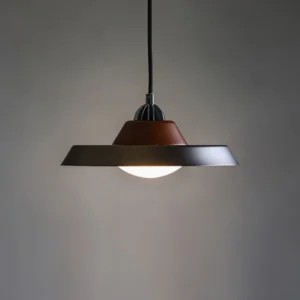 Black and walnut Far pendant lamp hanging against gray wall, mid-century modern design from front view